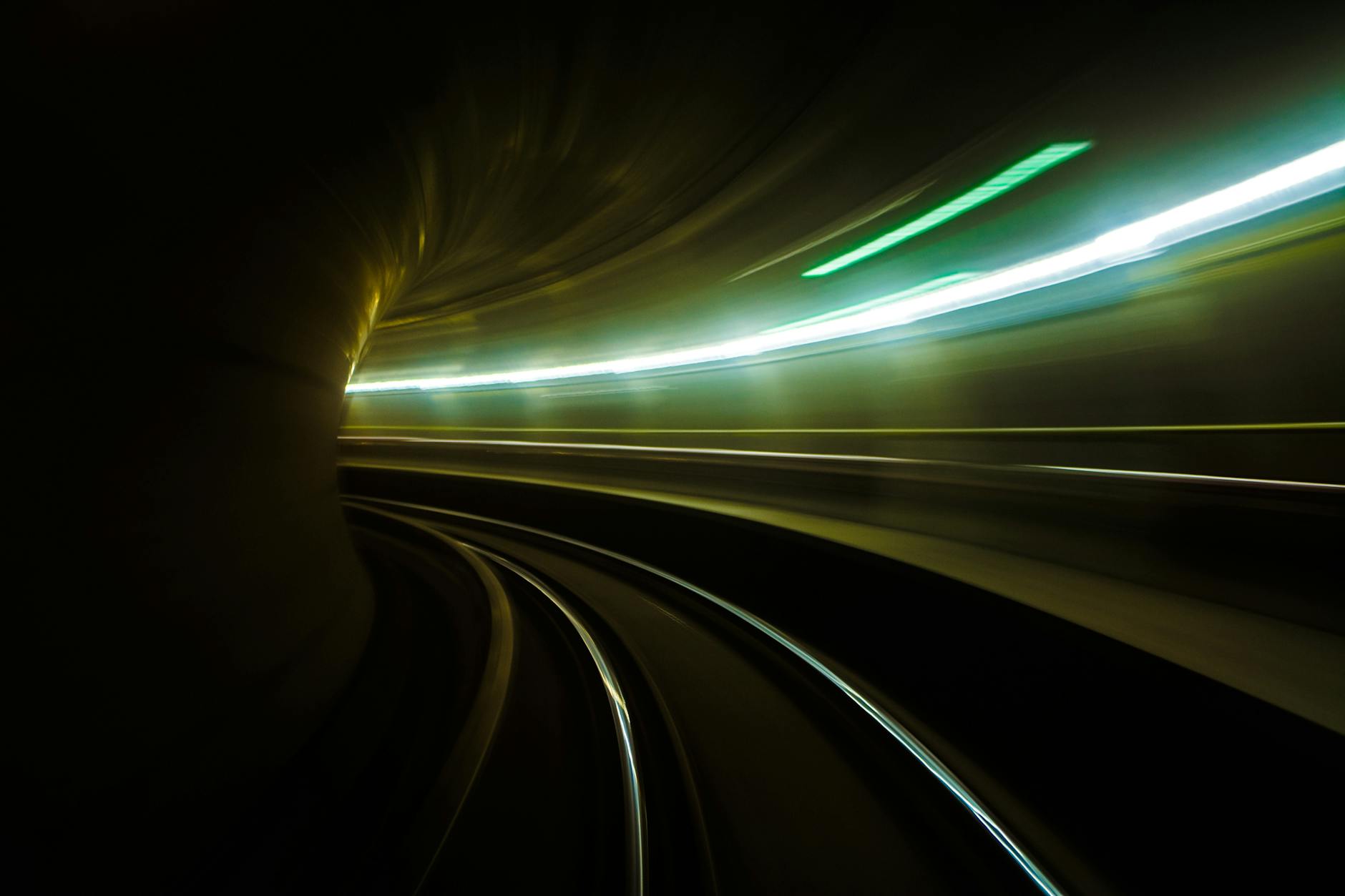 Blurred light streaks in a subway tunnel create a dynamic, futuristic effect.